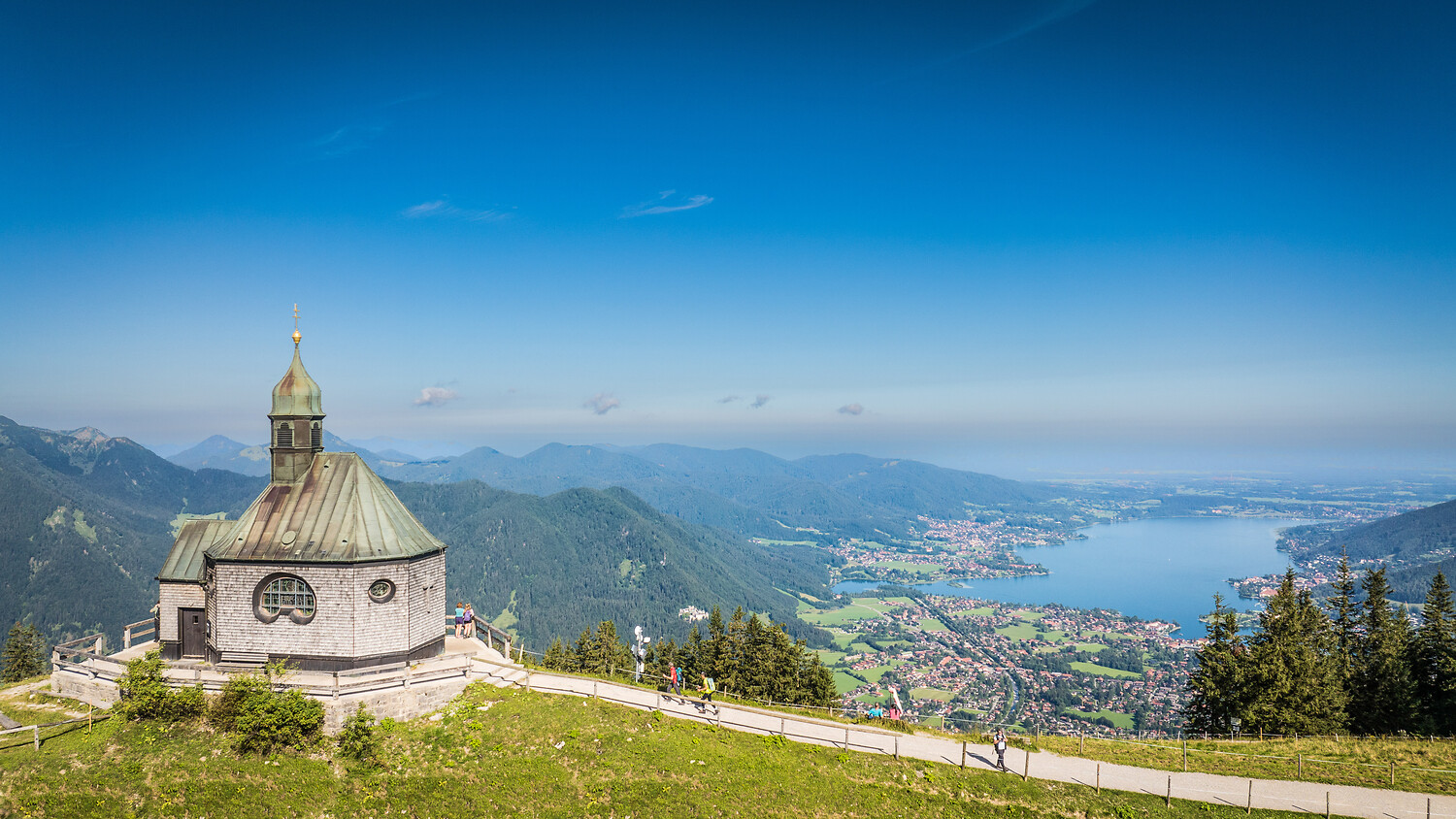 Vom Wallbergkircherl aus eröffnet sich im Sommer eine atemberaubende Aussicht auf die umliegende Bergwelt und den Tegernsee.